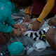 Paramedics and doctors try to revive a baby.